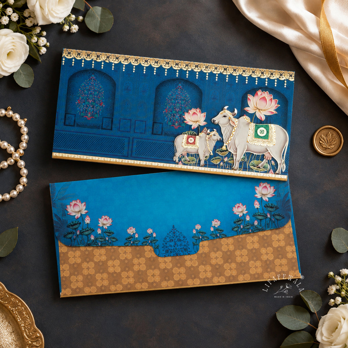 Blue Pichwai Cow and Calf velvet shagun envelope by LIFAFEWALA – styled flat lay